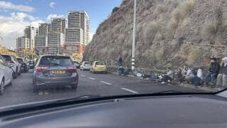 Los israelíes se refugian al costado de la carretera durante un ataque con misiles de Hezbollah el martes 19. 