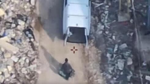 Un hombre armado cargando armas en un vehículo. 