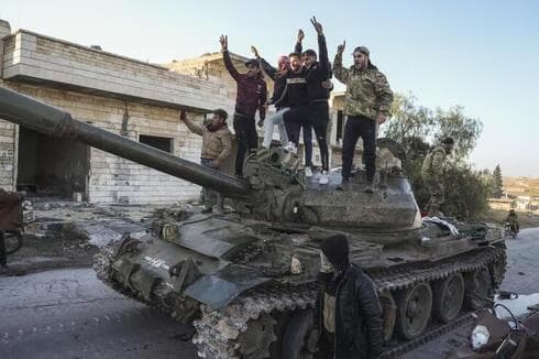Opositores a Assad celebran arriba de un tanque abandonado por el ejército sirio en la ciudad de Maarat al-Nu'man. 