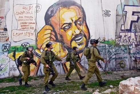 Soldados de las FDI pasan junto a un mural de Marwan Barghouti. (Nasser Shiyoukhi, AP) Soldados de las FDI pasan junto a un mural de Marwan Barghouti.