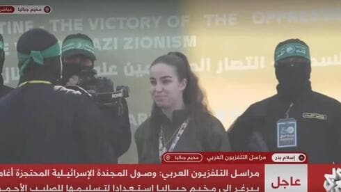 Agam Berger es entregada a la Cruz Roja por los militantes de Hamás. 