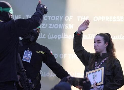 Agam Berger es entregada a la Cruz Roja por los militantes de Hamás. 