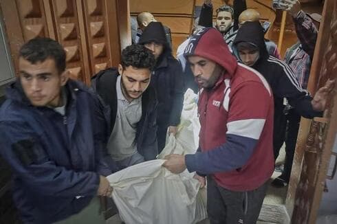 Palestinos trasladan cadáveres a pulso. 