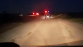 Los rescatistas se acercan a la ambulancia que se desvió de la carretera, antes de que comenzara el tiroteo 