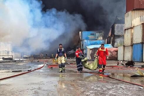 Rescatistas trabajan en el rescate y traslado de las víctimas de la explosión en el principal puerto de Irán. (AFP) Rescatistas trabajan en el rescate y traslado de las víctimas de la explosión en el principal puerto de Irán.