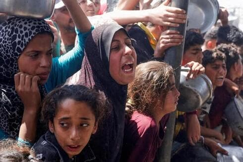 Los habitantes de Gaza se reúnen para recibir comida caliente de una cocina benéfica en Khan Younis. (Reuters, foto de archivo) Los habitantes de Gaza se reúnen para recibir comida caliente de una cocina benéfica en Khan Younis.