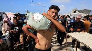 Jóvenes palestinos retiran alimentos del centro de ayuda