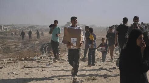 Jóvenes palestinos retiran alimentos del centro de ayuda
