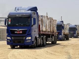 Camiones del fondo con ayuda se dirigen a Gaza. 