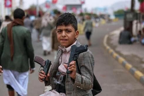 Niño armado en una manifestación de los hutíes en Yemen. 