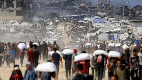 Multitudes de palestinos cargan bolsas con ayuda humanitaria en el norte de la Franja de Gaza. (Reuters) Multitudes de palestinos cargan bolsas con ayuda humanitaria en el norte de la Franja de Gaza.
