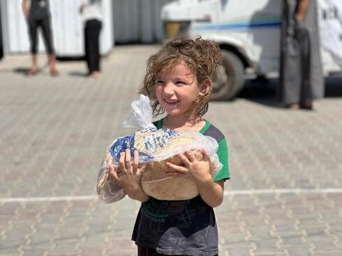 Niños palestinos acceden a la ayuda humanitaria. 