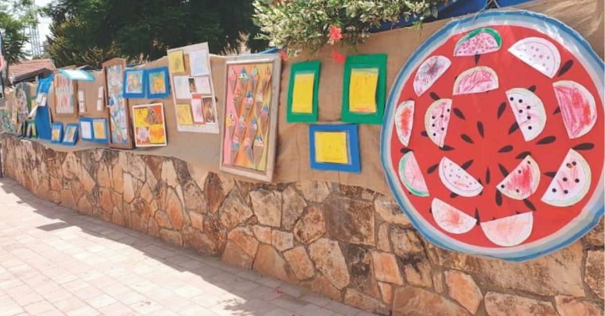 התערוכה מחוץ לגן. עוברי אורח נהנים מהצבעוניות