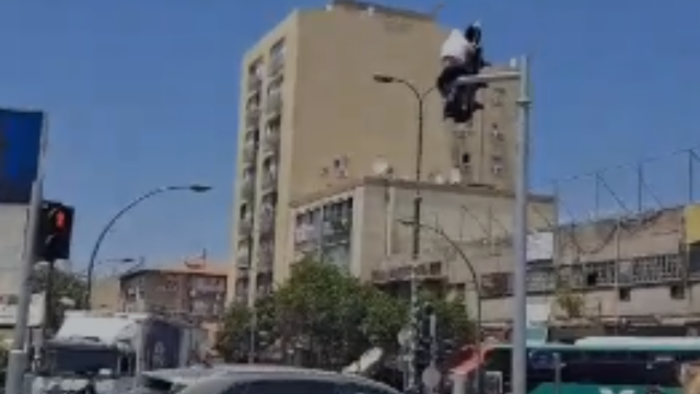 גבר טיפס על רמזור במרכז ראשל"צ
