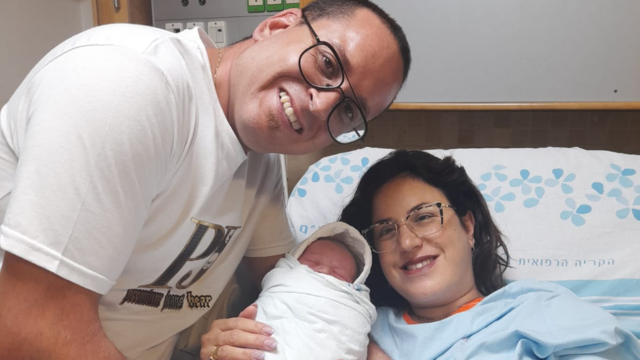 הזוג המאושר מחבקים את בן הזקונים