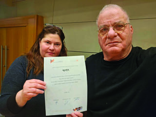 שני מציג בגאווה את תעודת ההוקרה