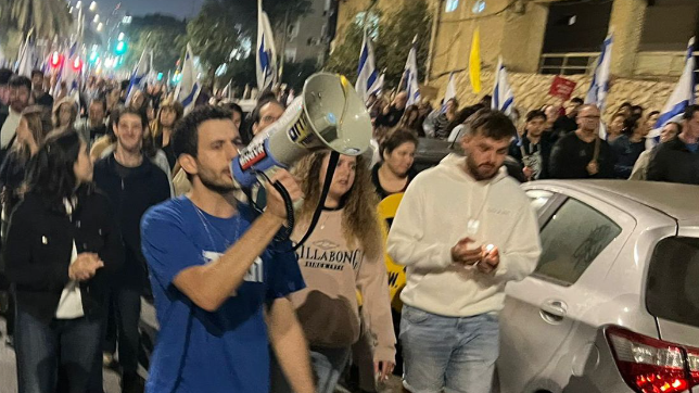 עידו אטיאס עם המגפון בהפגנה