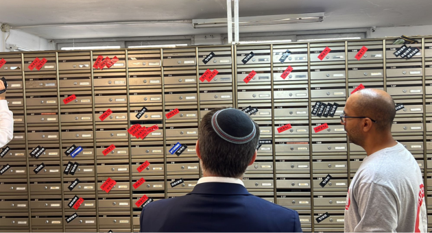 השר סמוטריץ' מול תאי הדואר של חברי ניר עוז, בהם מצוין מי מהם נרצח ומי עדיין חטוף