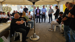 עובדי המפעל באוהל המחאה בפתח המפעל בנאות חובב