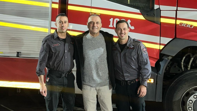 יעקב (במרכז) ולוחמי האש שהצילו את חייו