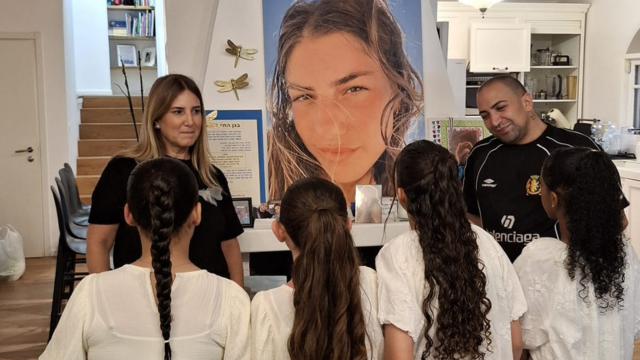 ענת נעים וגילי אלגבי עם בנות המצווה על רקע תמונת מאי ז"ל