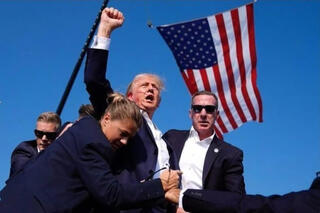 Donald Trump con sangre en el rostro, rodeado por agentes del Servicio Secreto. 