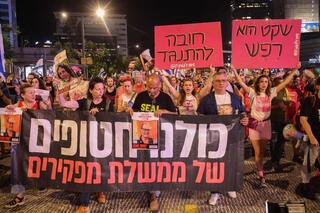 Manifestantes con un cartel que dice "Todos somos rehenes" durante una protesta en Tel Aviv. 