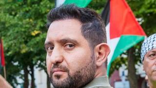 Iman Spati. De fondo, las banderas y los activistas propalestinos. 