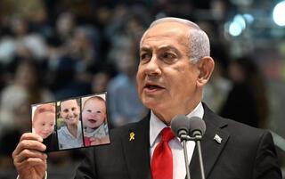 Benjamín Netanyahu con los retratos de Shiri, Ariel y Kfir. 