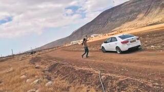 Otro joven extremista estrella una piedra contra un automóvil. 