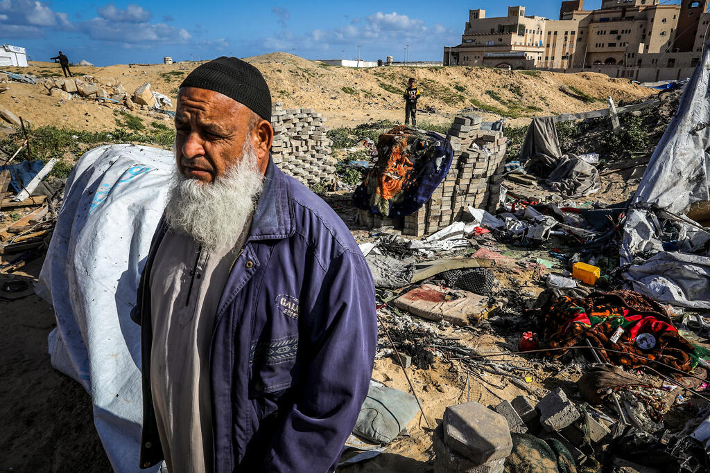 مسن فلسطيني يتفقد أضرار القصف الإسرائيلي في خان يونس