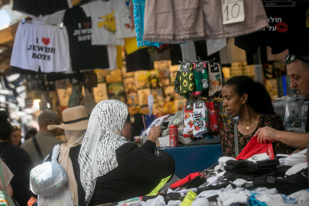 امرأة عربية محجبة تتسوق في سوق الكرمل بمدينة تل أبيب