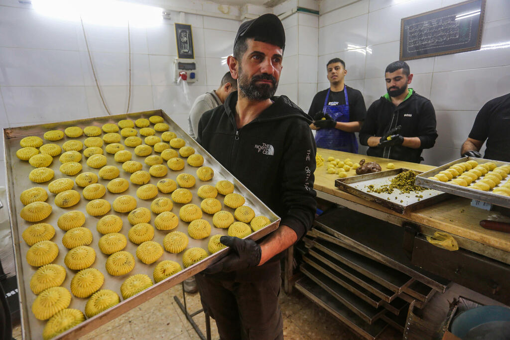 فلسطينيون يتسوقون استعدادًا لعيد الفطر في السوق بمدينة نابلس 