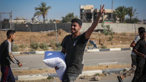 شاب غزيه بعد حصوله على الطحين في دير البلح