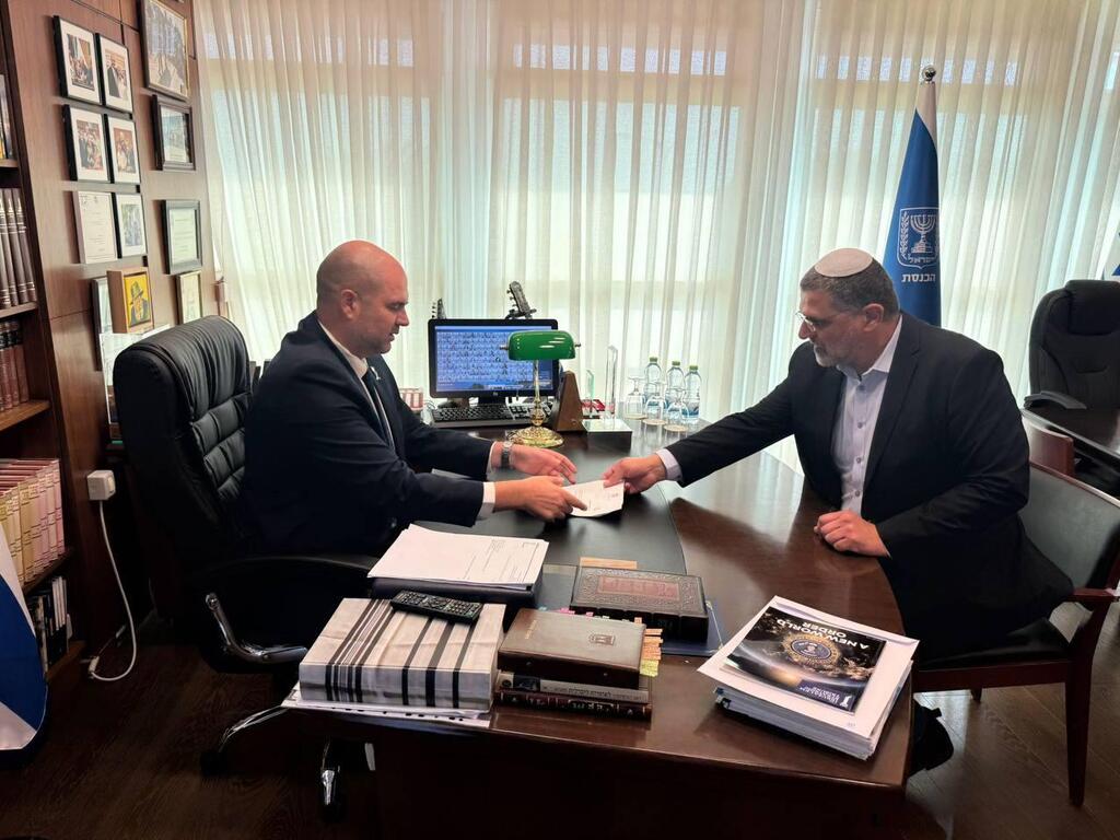 عضو الكنيست بؤرون يسلّم التواقيع اللازمة لرئيس الكنيست أمير أوحانا بعد استكمال جمعها (تُستخدم هذه الصورة بموجب البند 27 أ من قانون الحقوق الأدبية (2007)) بدعم من "المعسكر الرسمي": الكنيست يبدأ خطوات الإطاحة بأيمن عودة