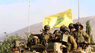 جنود إسرائيليون على متن مركبة مدرعة يحملون علم حزب الله تم الاستيلاء عليه خلال القتال  2006