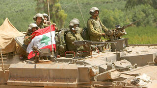 جنود إسرائيليون على متن مركبة مدرعة يحملون علم لبنان تم الاستيلاء عليه خلال القتال  2006