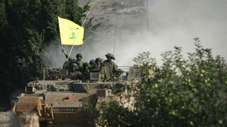 جنود إسرائيليون على متن مركبة مدرعة يحملون علم حزب الله تم الاستيلاء عليه خلال القتال  2006