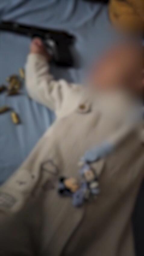 أب يلهو بسلاح فوق طفله