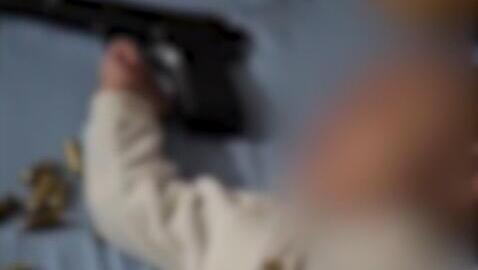 أب يلهو بسلاح فوق طفله