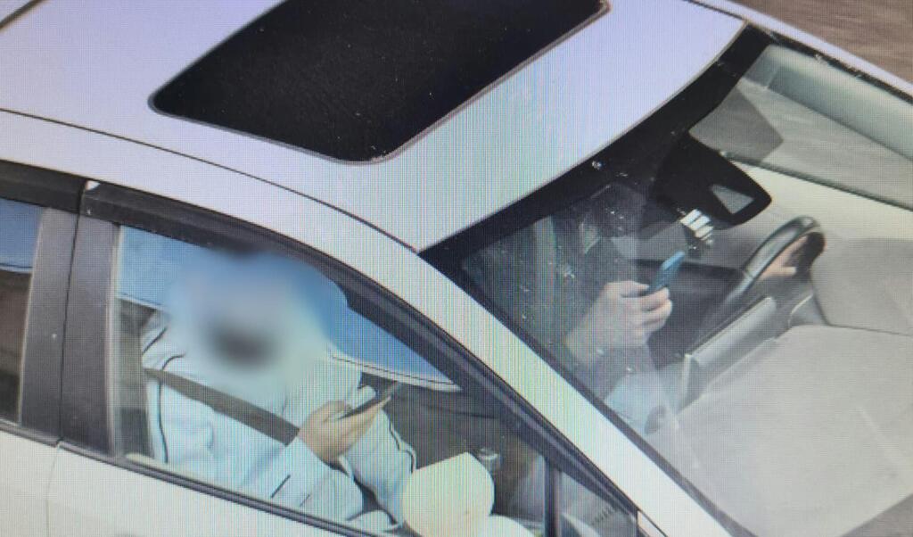 معلّم قيادة وتلميذه يوثَّقان باستخدام الهاتف أثناء الدرس قرب الناصرة