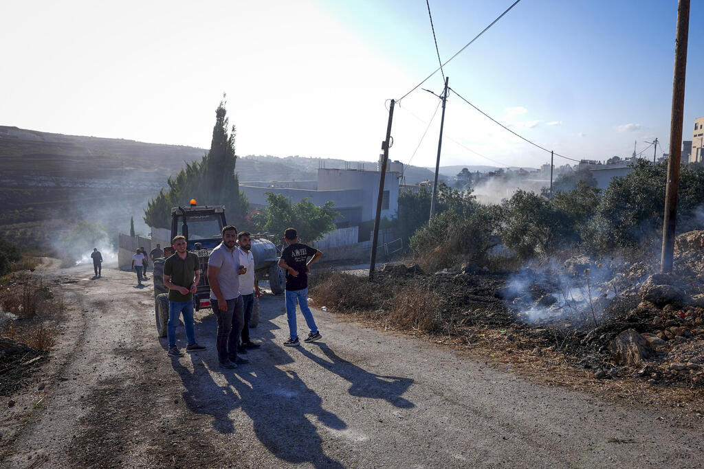 فلسطينيون يعاينون الأضرار التي خلفتها اعتداءات المستوطذنين في قرية التل