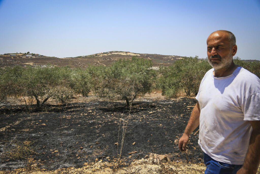 فلسطينيون يعاينون الأضرار التي خلفتها اعتداءات المستوطذنين في قرية التل